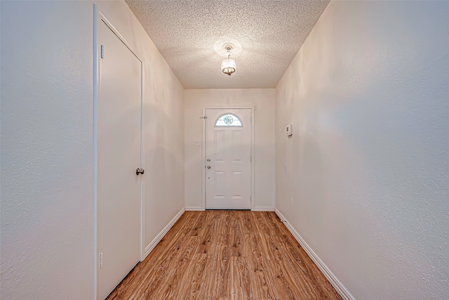 doorway featuring light hardwood / wood-style flooring and a textured ceiling