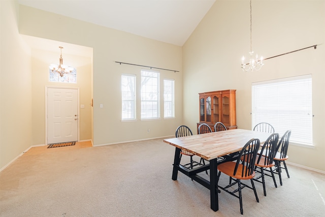 dining room with high vaulted ceiling, light colored carpet, and a notable chandelier