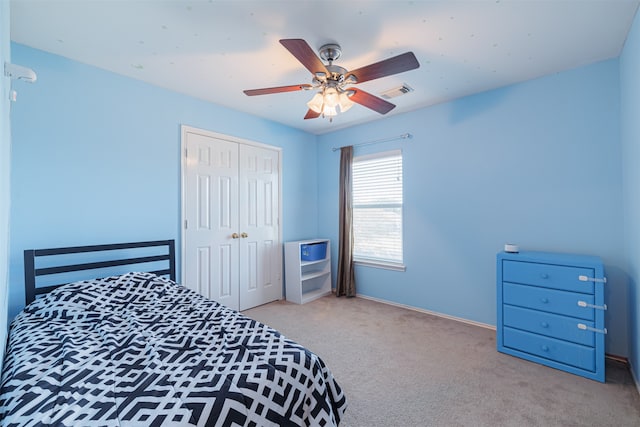 carpeted bedroom with ceiling fan and a closet