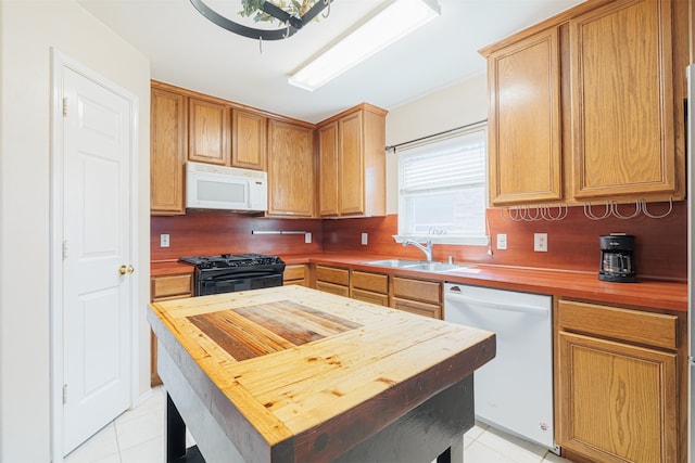 kitchen with decorative backsplash, sink, white appliances, and light tile patterned flooring