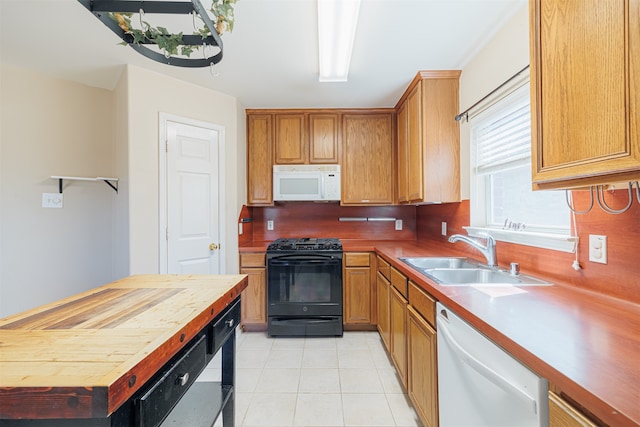 kitchen with white appliances, sink, light tile patterned floors, and wood counters