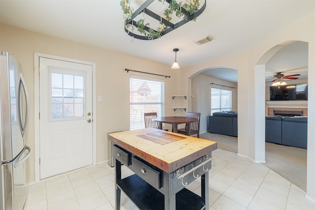 dining space featuring light tile patterned flooring and a fireplace