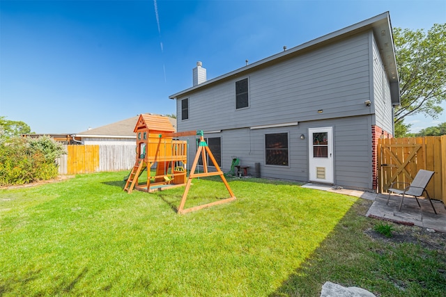 rear view of property featuring a playground and a lawn