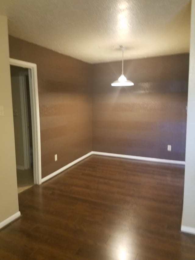 unfurnished dining area with dark wood-type flooring