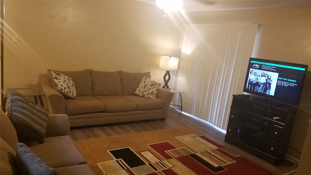 living room featuring lofted ceiling and hardwood / wood-style floors