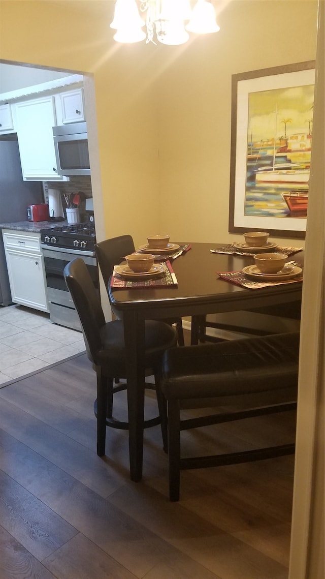 dining area with wood-type flooring and an inviting chandelier