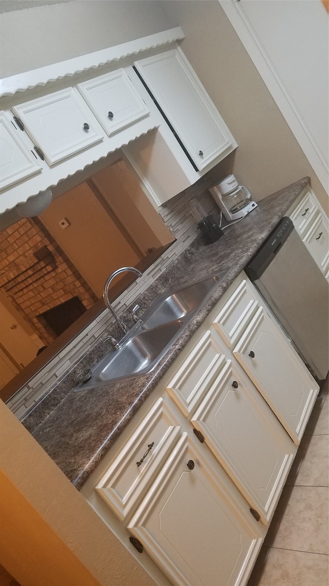 kitchen with sink, light tile patterned floors, and white cabinets