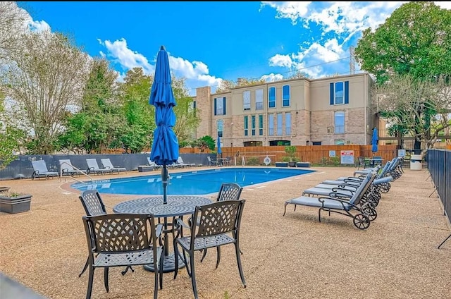 pool featuring fence and a patio
