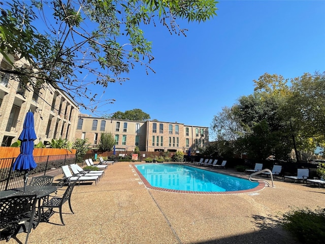 pool with a patio and fence