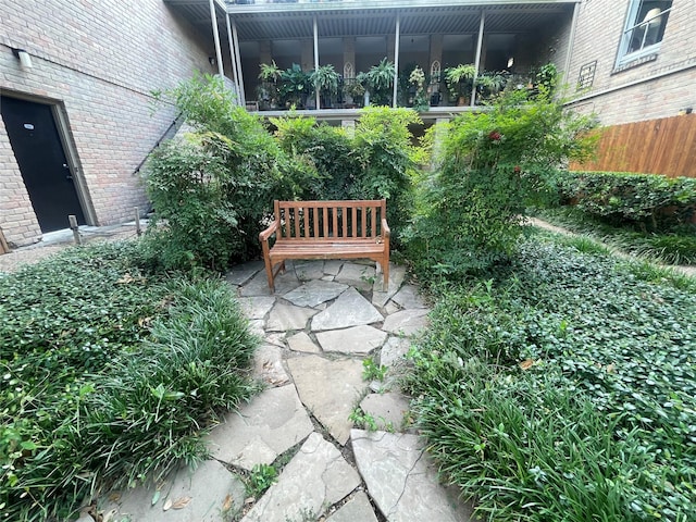 view of patio with fence and a sunroom