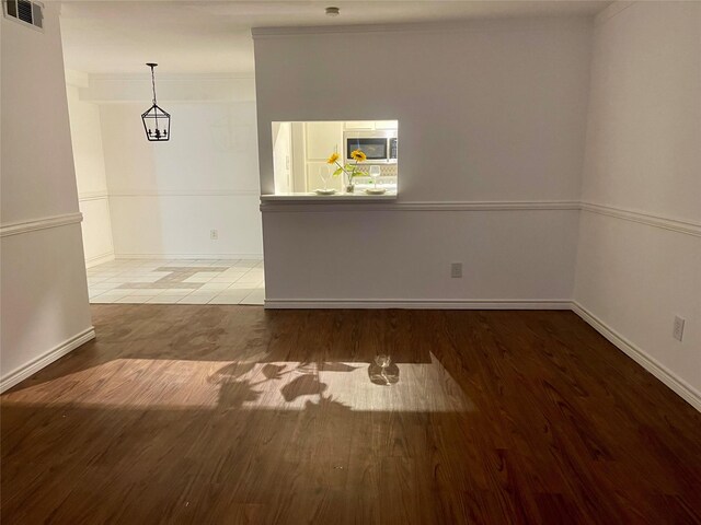 unfurnished room featuring wood finished floors, baseboards, and visible vents