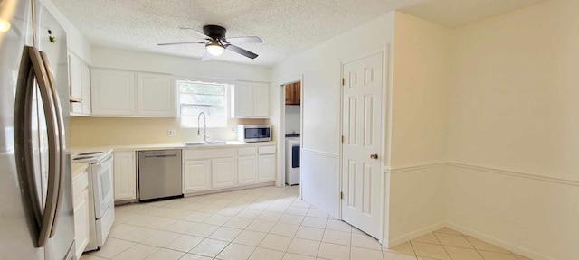 kitchen featuring ceiling fan, white cabinets, light tile patterned flooring, sink, and appliances with stainless steel finishes