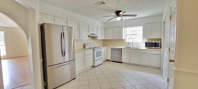 8 Abalone St, Bay City, TX 77414 - kitchen featuring stainless steel appliances, a sink, a ceiling fan, under cabinet range hood, and white cabinetry