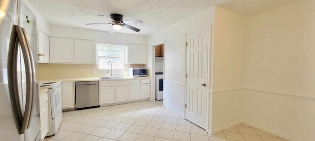 8 Abalone St, Bay City, TX 77414 - kitchen featuring appliances with stainless steel finishes, a sink, white cabinetry, a ceiling fan, and a textured ceiling