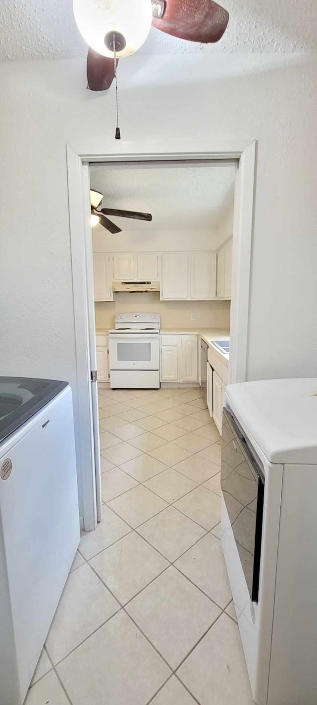 kitchen with light tile patterned floors, white cabinetry, white appliances, and washer / dryer