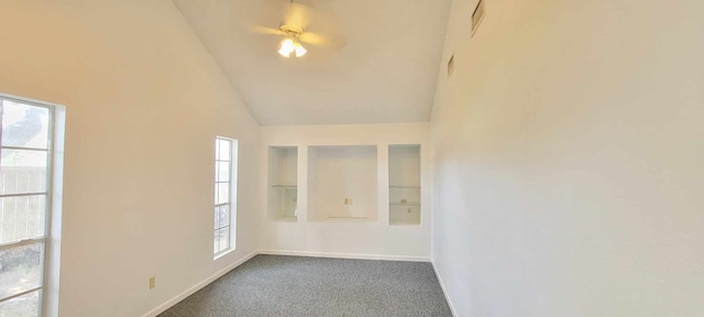 spare room with dark colored carpet and high vaulted ceiling