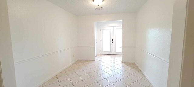 8 Abalone St, Bay City, TX 77414 - unfurnished room with baseboards, a textured ceiling, light tile patterned flooring, and french doors