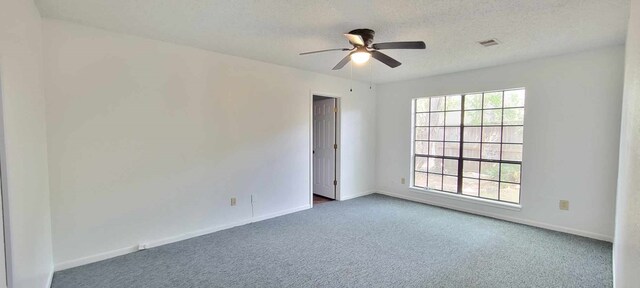 8 Abalone St, Bay City, TX 77414 - empty room with dark colored carpet, ceiling fan, baseboards, and a textured ceiling