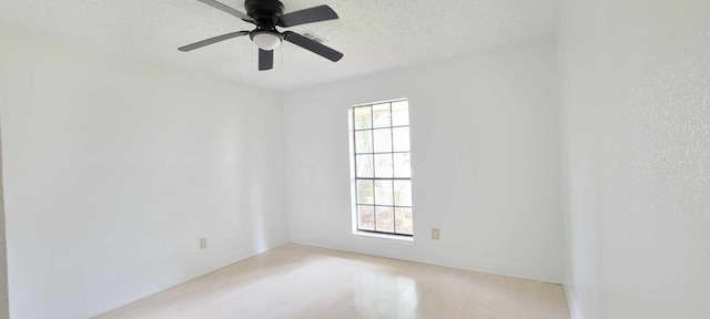 spare room with ceiling fan, a textured ceiling, light wood-type flooring, and plenty of natural light