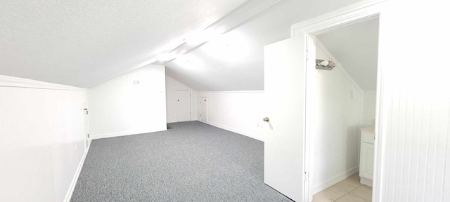 bonus room featuring light carpet, vaulted ceiling, and a textured ceiling