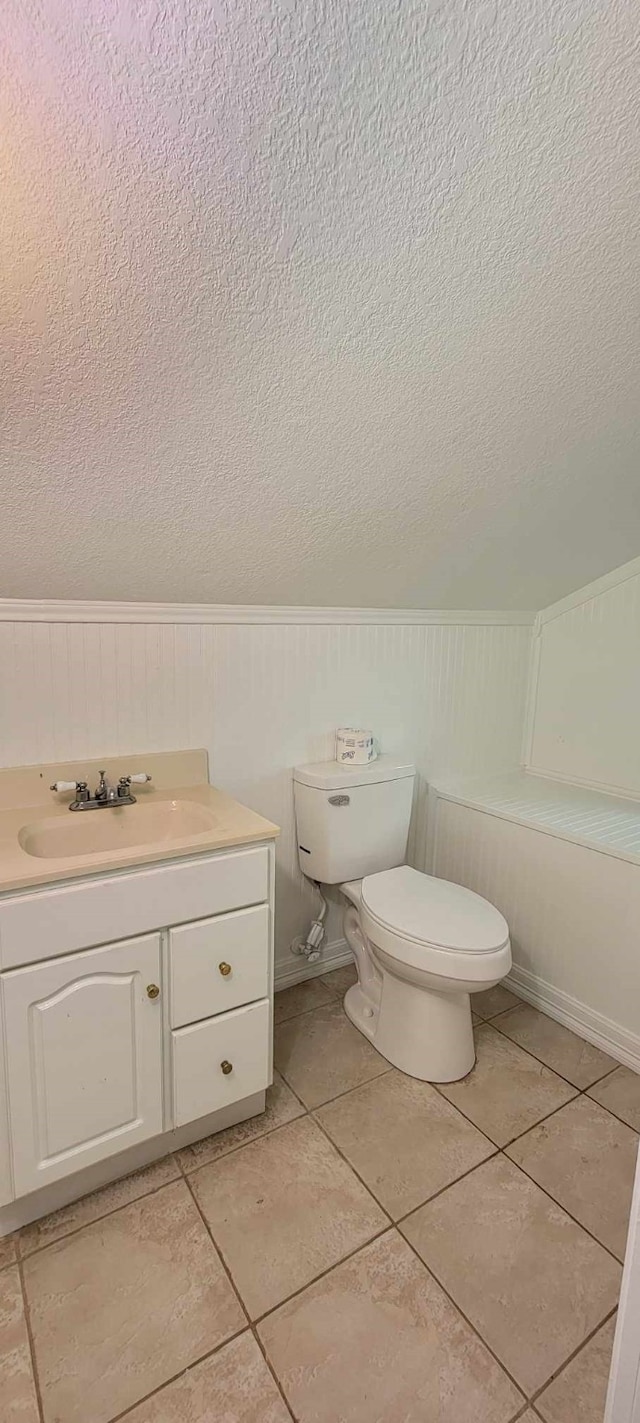 bathroom with vanity, tile patterned flooring, toilet, and a textured ceiling