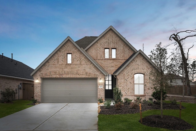 view of front of house featuring a front yard, concrete driveway, brick siding, and an attached garage