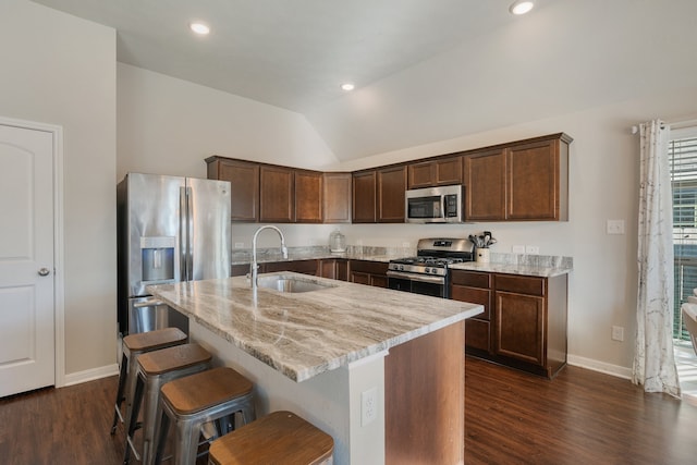 kitchen with dark hardwood / wood-style floors, a kitchen island with sink, sink, lofted ceiling, and stainless steel appliances