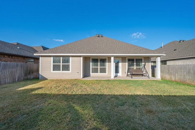 back of house featuring a lawn and a patio area