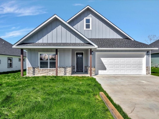 view of front of property featuring a garage, stone siding, a shingled roof, and board and batten siding