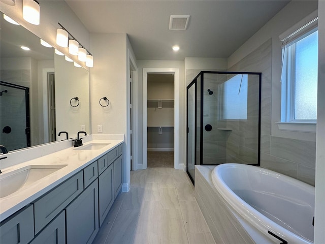 bathroom with vanity and independent shower and bath