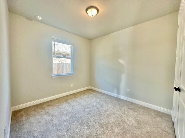 spare room featuring light colored carpet