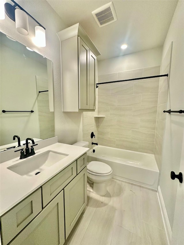 full bathroom with toilet, tiled shower / bath combo, and vanity