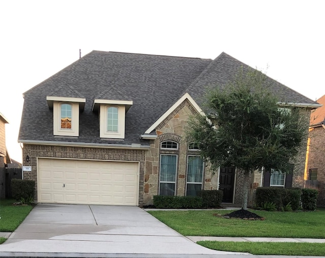 331 W Bend Dr, League City, TX 77573 - view of front of home with driveway, a front lawn, a garage, stone siding, and a shingled roof