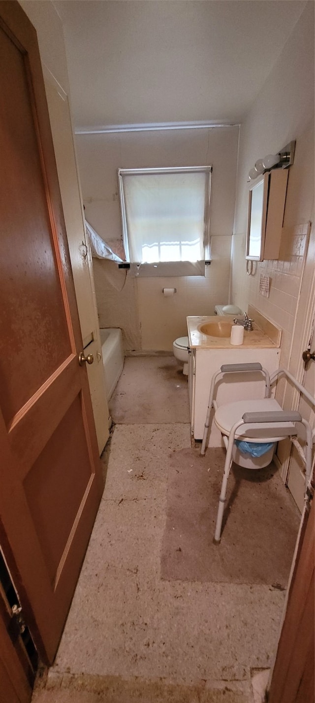 bathroom featuring vanity, tile walls, and toilet