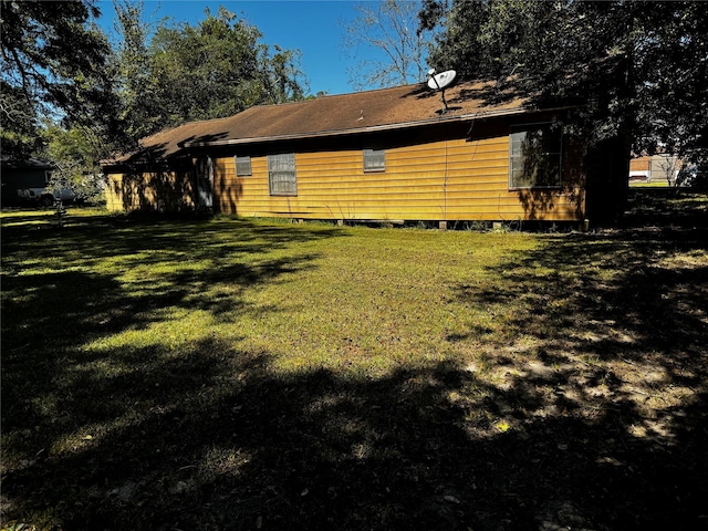235 W Hartel St, Sour Lake, TX 77659 - rear view of property featuring a lawn