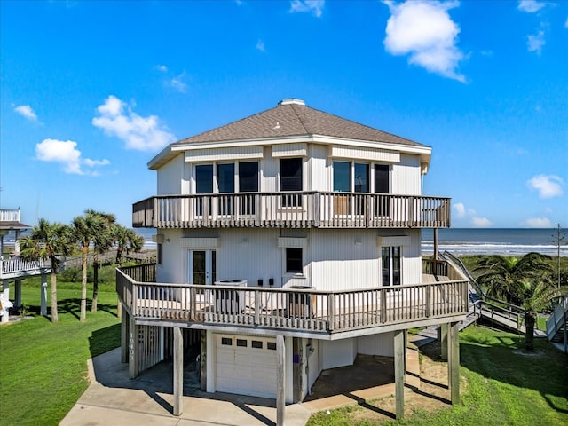 back of house featuring a water view, a yard, a garage, and a balcony