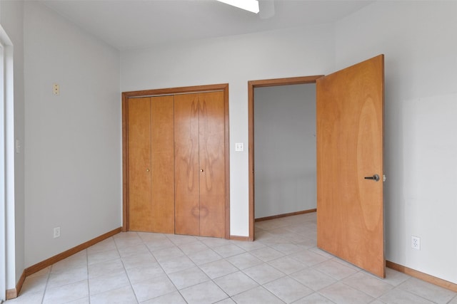 unfurnished bedroom with light tile patterned floors, baseboards, and a closet