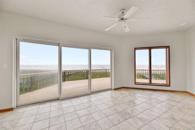 unfurnished room with baseboards, a ceiling fan, light tile patterned floors, and a healthy amount of sunlight