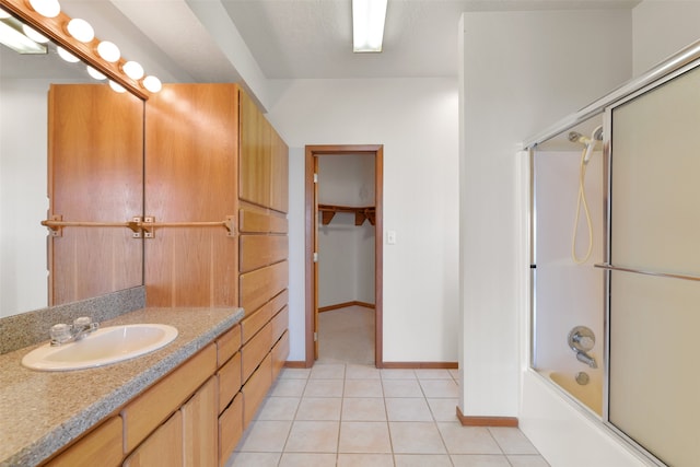 bathroom featuring enclosed tub / shower combo, tile patterned flooring, and vanity