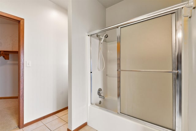full bathroom with baseboards, tile patterned flooring, and bath / shower combo with glass door