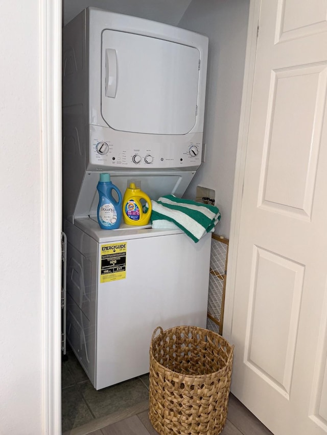 clothes washing area with estacked washer and dryer and tile patterned flooring