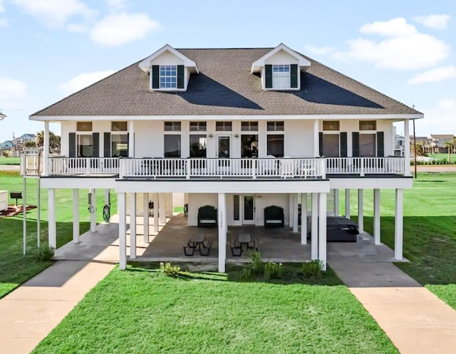 view of front facade with a front lawn, roof with shingles, a carport, and stucco siding