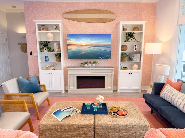 living room with wallpapered walls, wood finished floors, a fireplace, and baseboards