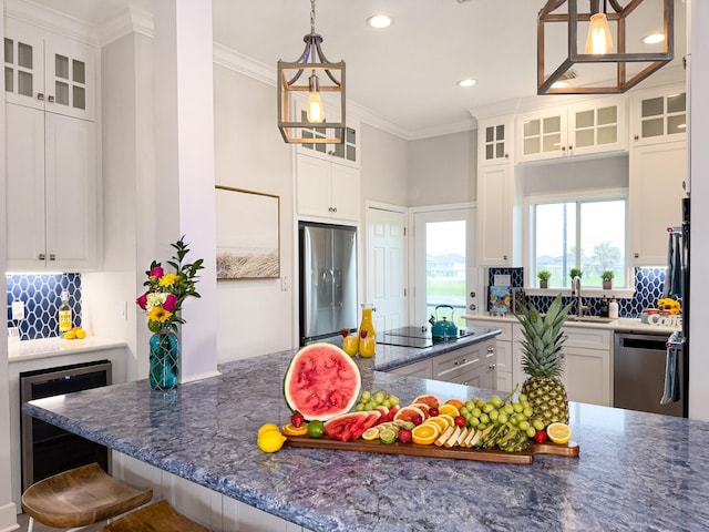 kitchen with appliances with stainless steel finishes, beverage cooler, ornamental molding, a sink, and decorative backsplash