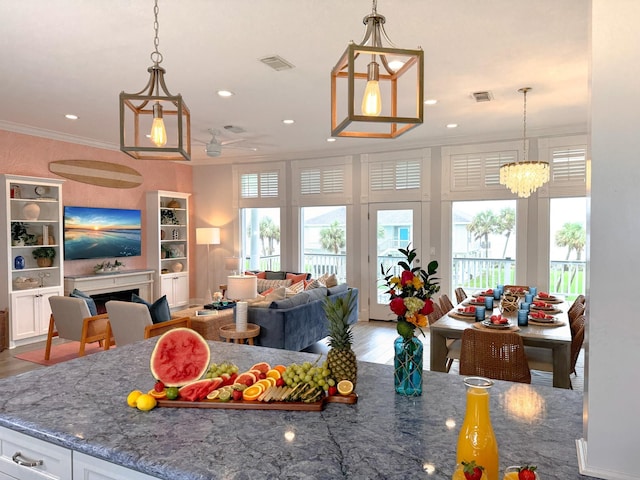 living area with healthy amount of natural light, crown molding, recessed lighting, wood finished floors, and a ceiling fan
