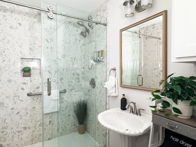 bathroom featuring a sink and a shower stall