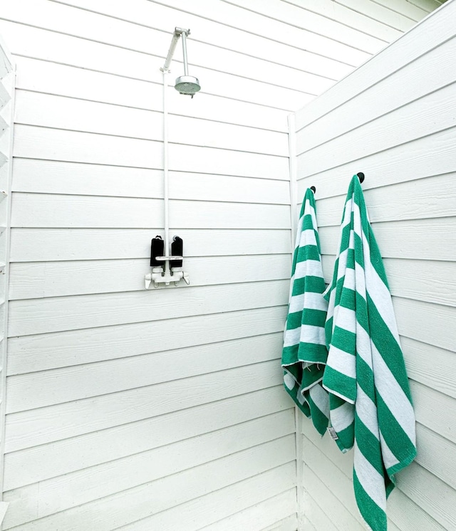 bathroom featuring wood walls and a tile shower