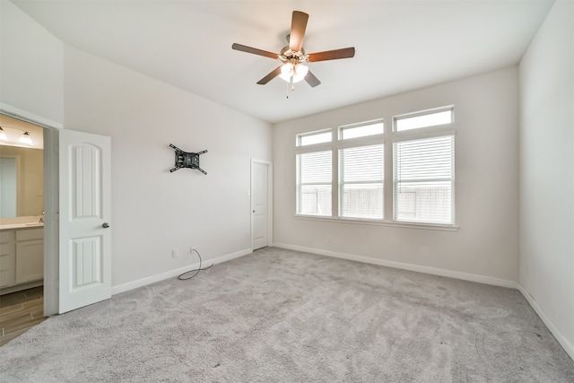 spare room featuring light carpet and ceiling fan