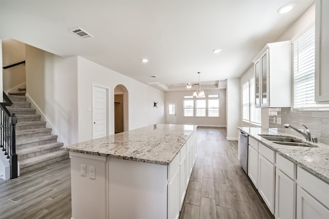 kitchen featuring tasteful backsplash, a center island, sink, and white cabinets