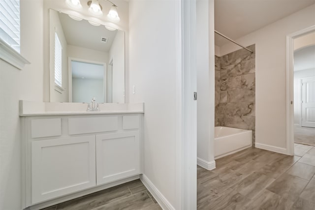 bathroom featuring tiled shower / bath, hardwood / wood-style flooring, and vanity